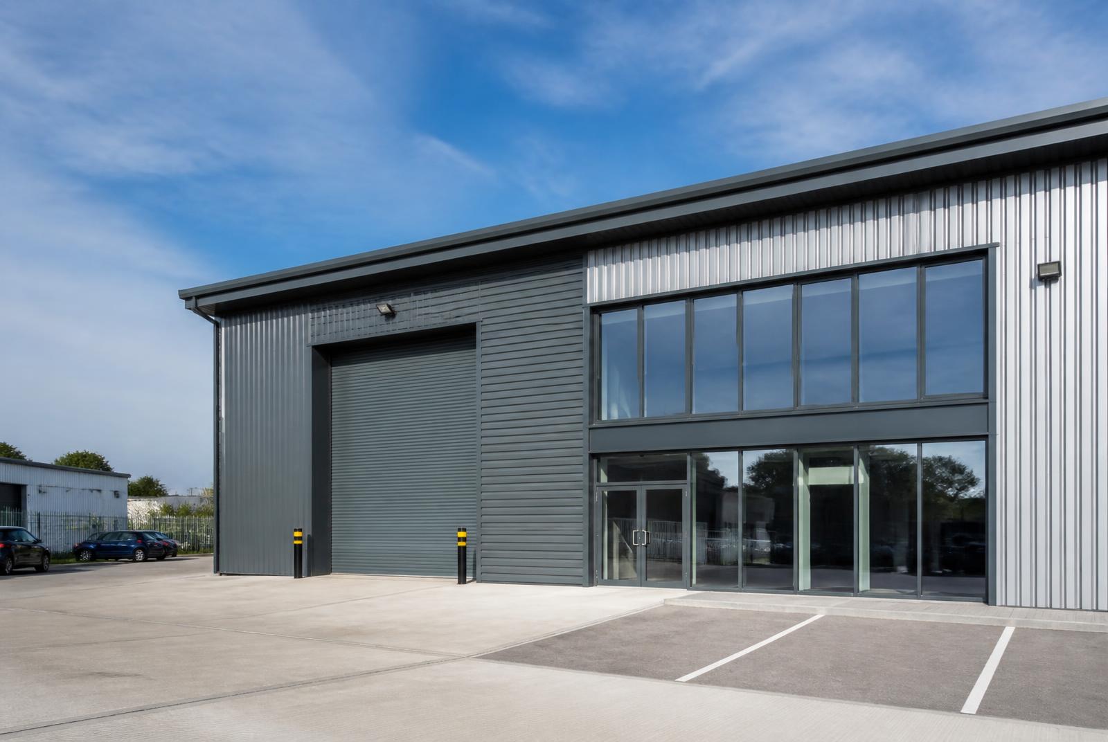 Exterior of a modern industrial unit with cladding, roller shutter and forecourt